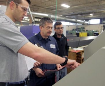 Members of the DaCruz Manufacturing team at one of their machines